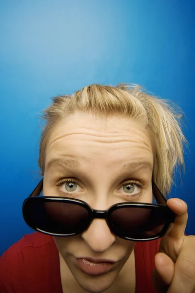Donna che indossa occhiali da sole con espressione facciale umoristica — Foto Stock