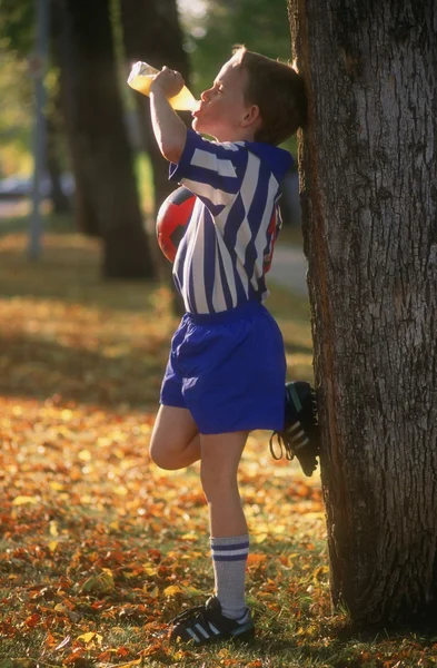 Jugador de fútbol joven bebiendo jugo — Foto de Stock