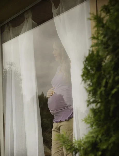 Schwangere wartet am Fenster — Stockfoto