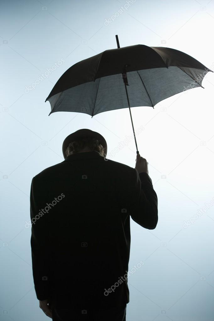 Person With Head Down Holding Umbrella