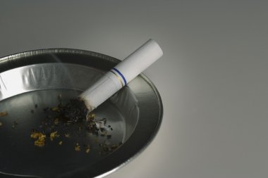 Smoldering Cigarette In Ashtray clipart