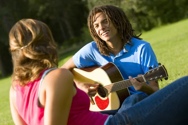 女の子のためのギターを弾く少年 — ストック写真