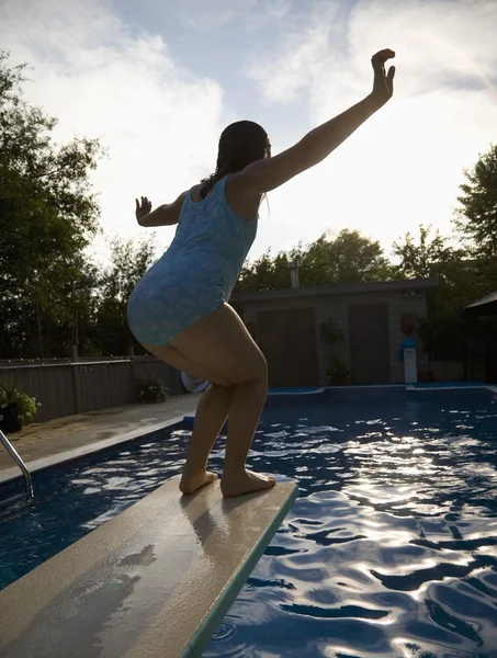 Fille sur planche de plongée sur piscine — Photo