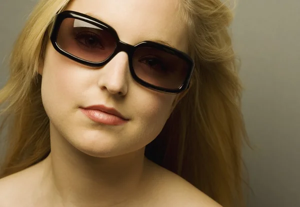 Jovem mulher usando óculos de sol — Fotografia de Stock