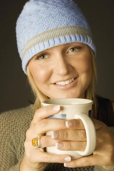 Mujer joven sosteniendo una taza — Foto de Stock