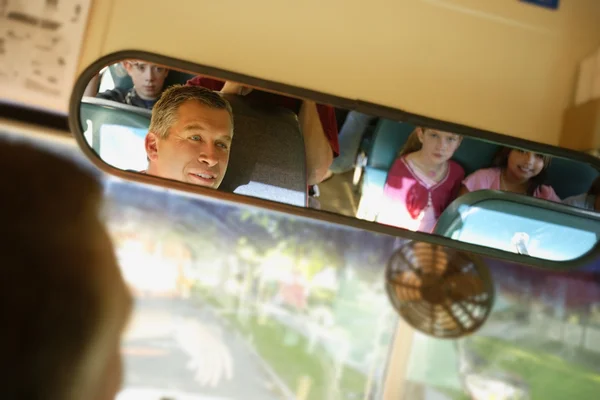 Enfants dans l'autobus scolaire à travers le miroir des conducteurs — Photo