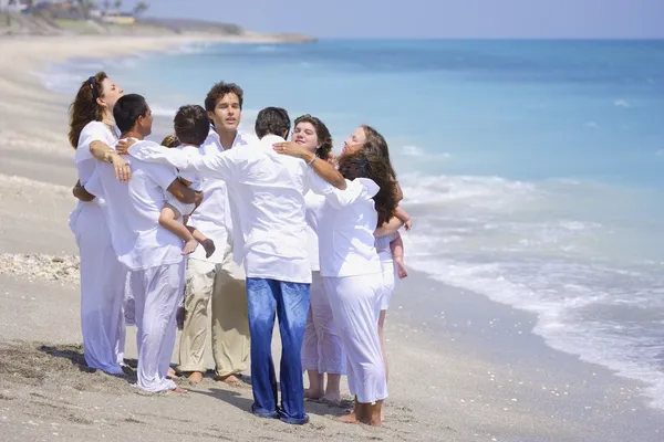 Een groep mensen samen bidden op het strand — Stockfoto