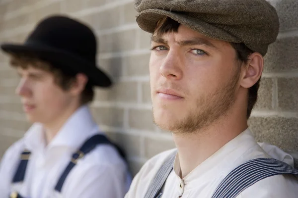 Men In Old-Fashioned Clothing Standing Against A Brick Wall — Stock Photo, Image