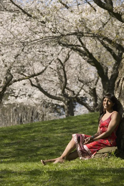 Vrouw ontspannen onder kersenboom blossoms — Stockfoto