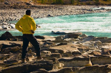 Man Overlooking A Mountain River clipart