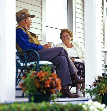 bir verandada oturan yaşlı bir çift