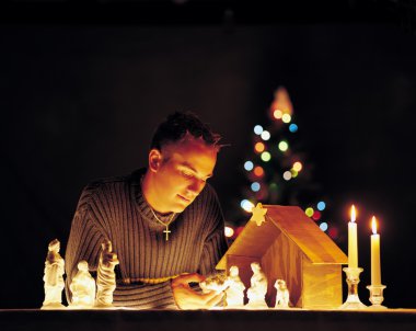 Man With Nativity Scene Figurines And Lights clipart
