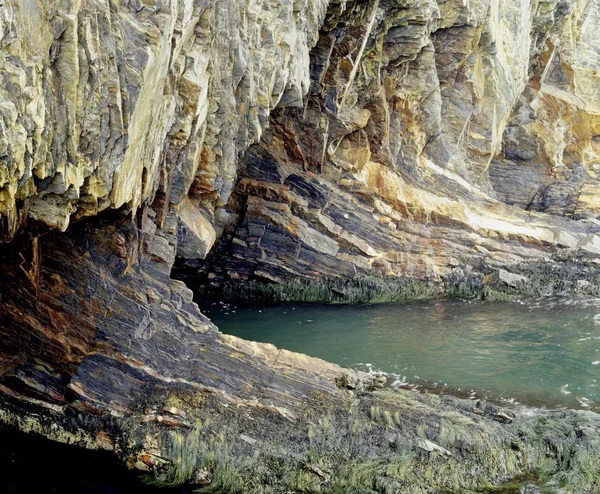 Rocky grotta med vatten som rinner in i den — Stockfoto
