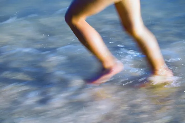 Niño corriendo a través del surf —  Fotos de Stock