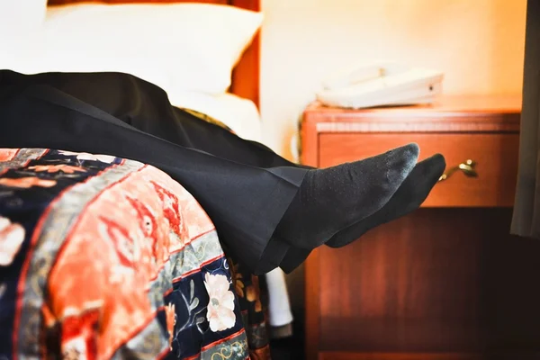 Maschio piedi appeso off di letto — Foto Stock