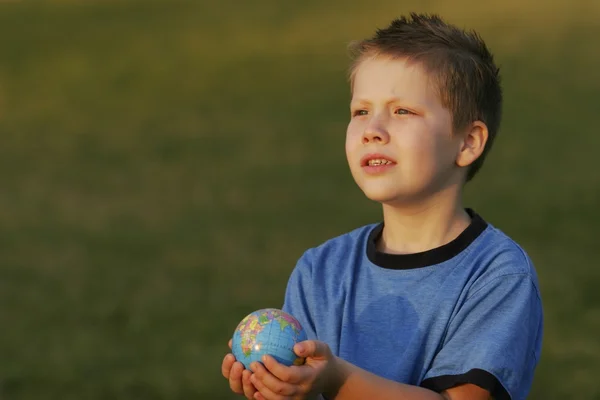 Jongen bedrijf een globe in zijn handen — Stockfoto