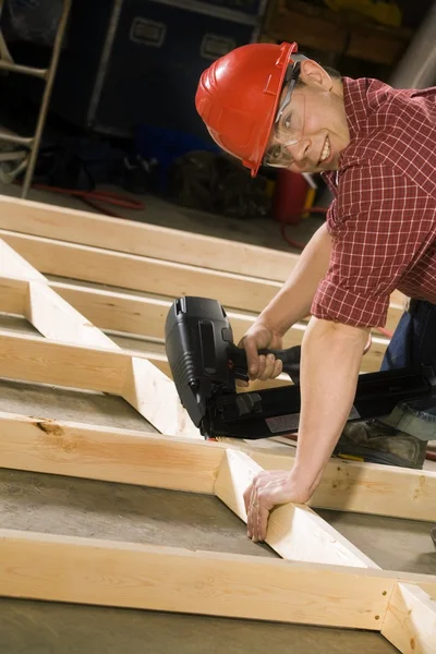 Carpinteiro de conteúdo trabalhando com ferramenta elétrica — Fotografia de Stock