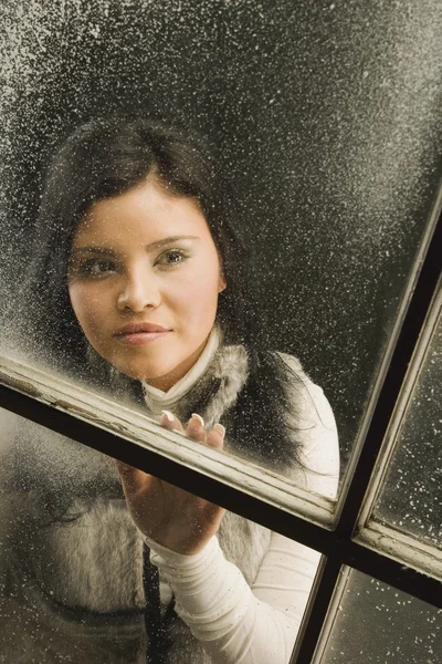 Frau schaut aus dem Fenster — Stockfoto