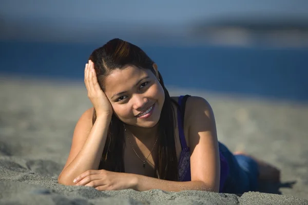 Una giovane donna sdraiata sulla spiaggia — Foto Stock