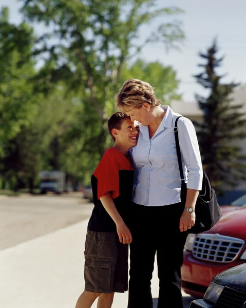 Mujer sonriendo y abrazando hijo — Foto de Stock