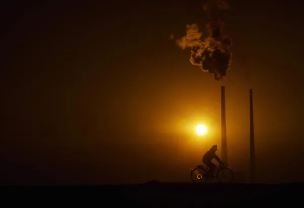 Człowiek na rowerze przez poolbeg elektrownia, poolbeg, dublin, Irlandia — Zdjęcie stockowe
