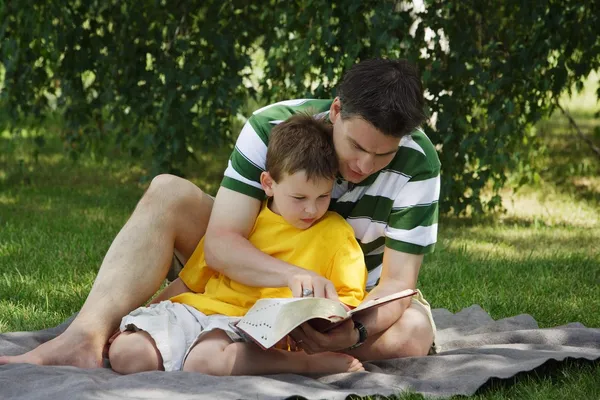 Père lisant à son fils — Photo