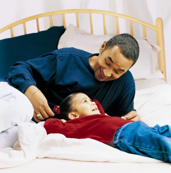 Padre y niña hablando en una cama — Foto de Stock