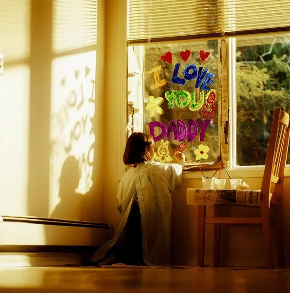 Chica pintando la ventana con te amo papá —  Fotos de Stock