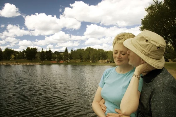 Una pareja junto a un lago — Foto de Stock