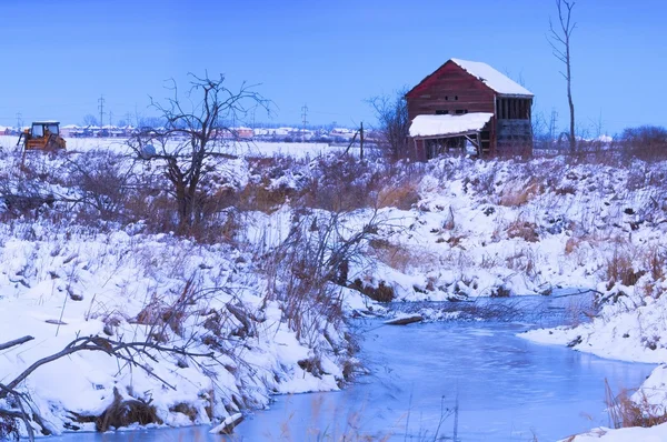 Verlaten shack in de buurt van bevroren winter creek — Stockfoto