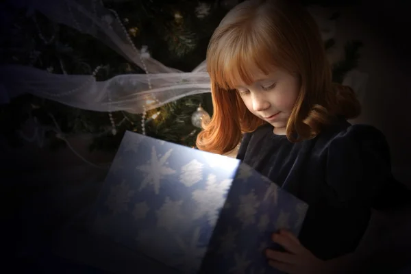 Ragazza guardando dentro un regalo di Natale — Foto Stock