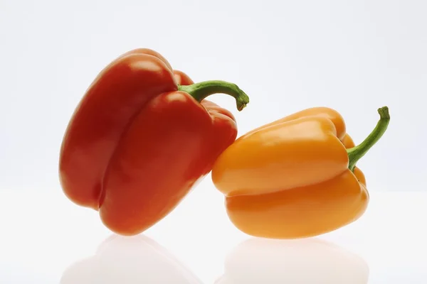 Pimienta roja apoyada en un pimiento naranja — Foto de Stock