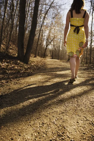 Dikiz çakıl yol üzerinde yürüyen kadın — Stok fotoğraf