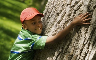 jongen knuffelen boomstam