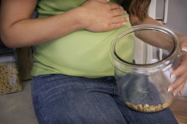 Pregnant Woman With An Empty Cookie Jar clipart