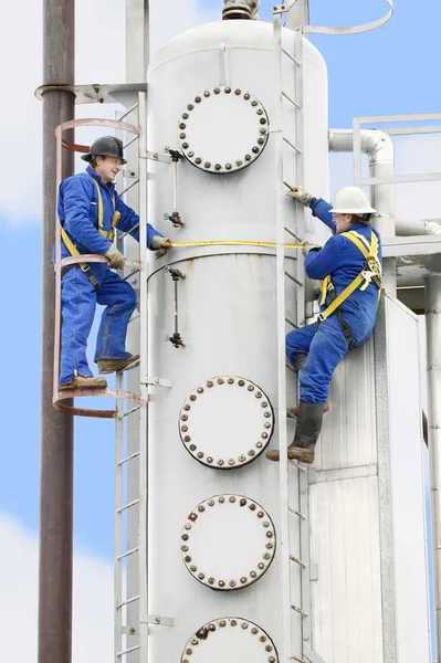 bir petrol rafinerisinde çalışan insanlar