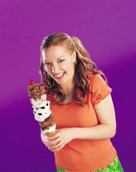 Chica sosteniendo un alto cono de helado —  Fotos de Stock