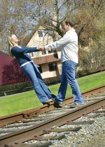 Casal segurando as mãos na trilha ferroviária — Fotografia de Stock