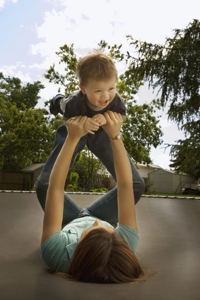 トランポリンで息子と遊ぶ母 — ストック写真