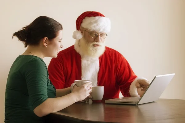 Mujer y Santa usando un ordenador portátil — Foto de Stock