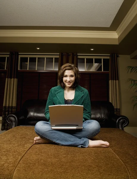 Frau arbeitet im Wohnzimmer am Laptop — Stockfoto