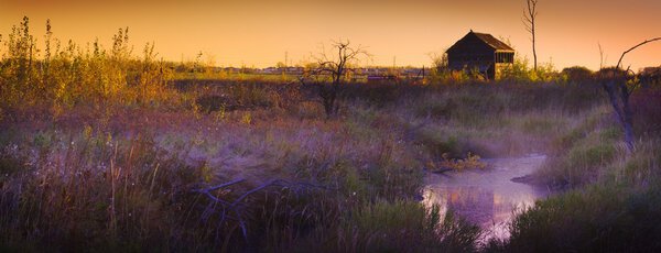 Abandoned Shack At Sunset Near A Creek
