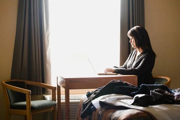 Donna che lavora al computer in camera d'albergo — Foto Stock