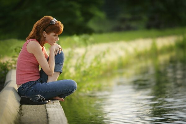 Women Sitting At Edge Of Lake