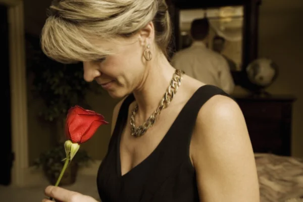 Žena voní rudá růže — Stock fotografie