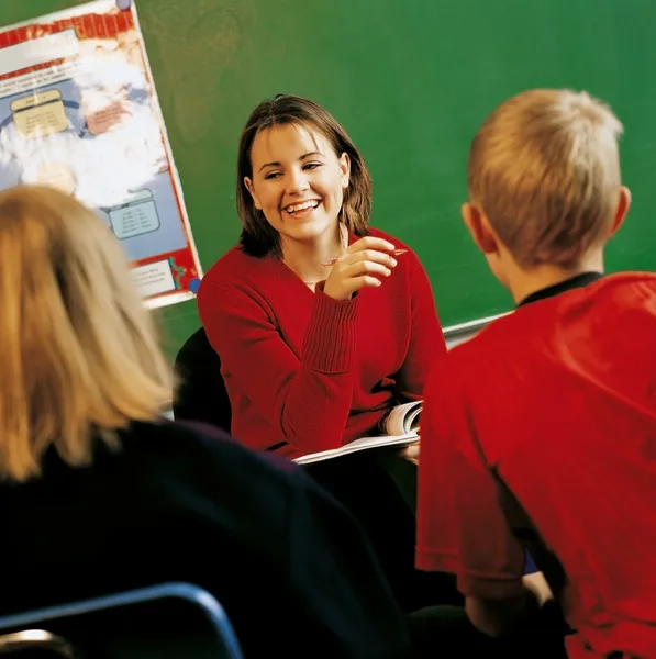 Un enseignant avec des élèves dans une salle de classe — Photo