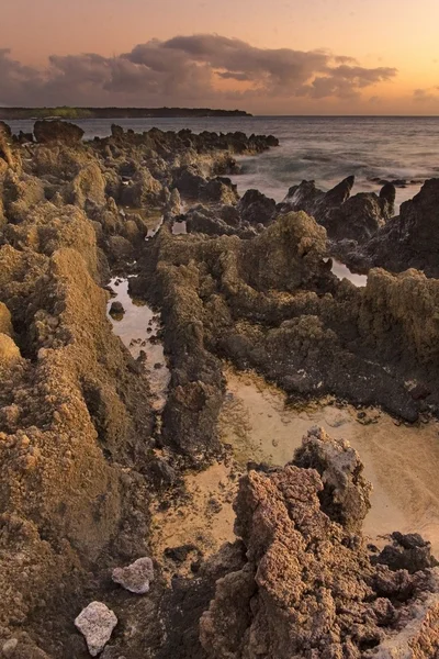 Vulkáni kőzetek, a strand és a felhők a láthatáron — Stock Fotó