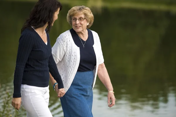 Zwei Frauen gehen neben einem See spazieren — Stockfoto