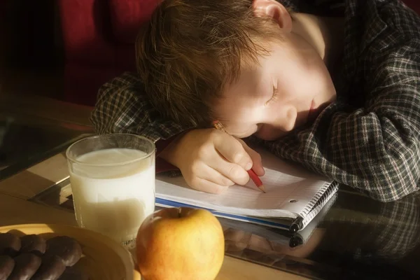 Pojken sover på läxor — Stockfoto