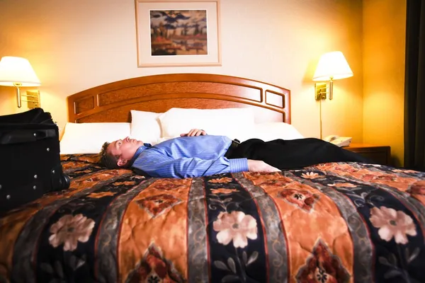 A Man Laying On A Bed In A Hotel Room — Stock Photo, Image